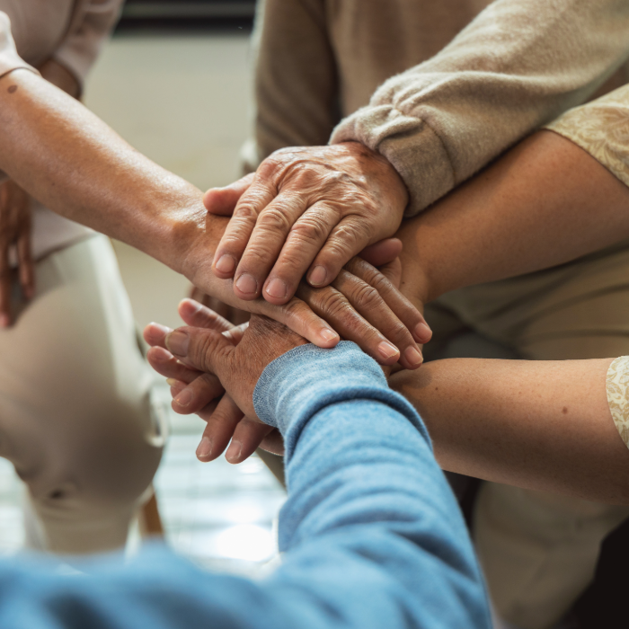 Hands stacked together in a gesture of support and teamwork.